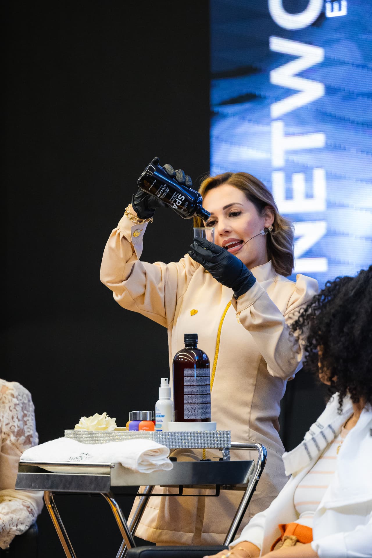 Daiane Carneiro demonstrando aplicação de protocolo capilar durante evento ao vivo